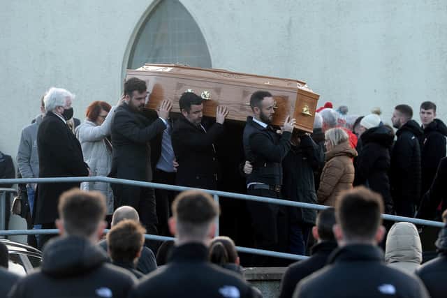 Family members hold onto the coffin of Nathan Corrigan, 20, as it is carried from St Matthew's Church