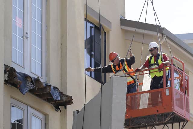 Workers remove part of a fourth floor balcony that collapsed in 2015, causing what has now become seven deaths (AP Photo/Jeff Chiu)