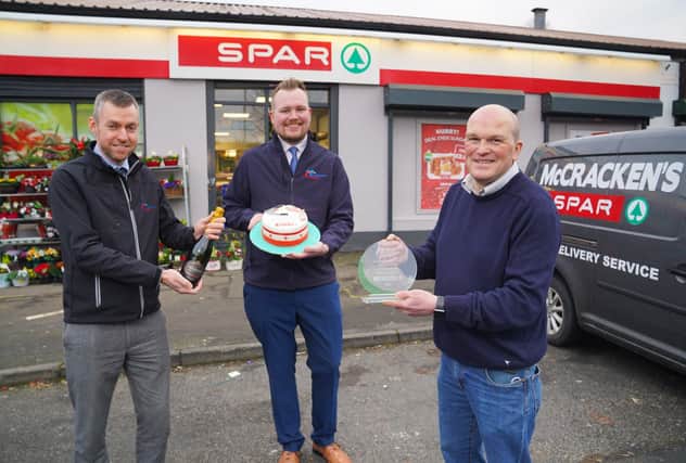 Ciaran Haren and Justin Hayes from Henderson Group present a commemorative plaque from SPAR NI to celebrate 50 years of business with owner James McCracken from McCrackens SPAR in Portadown
