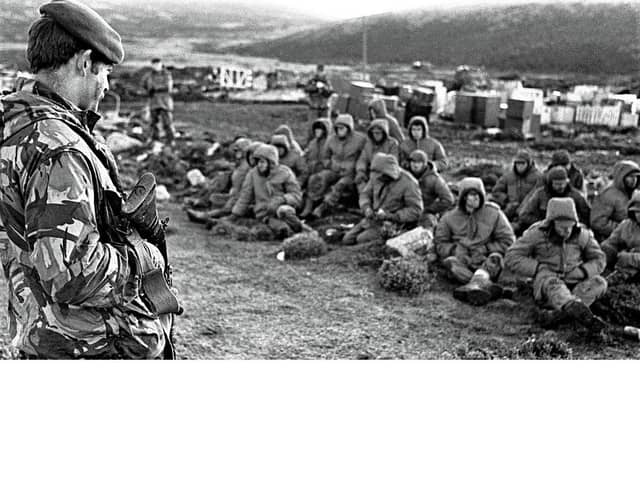 A Royal Marine guards Argentine prisoners during the war in 1982