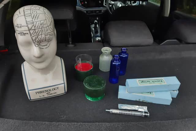 Debbie's items include a phrenology head map, a measuring cup, some medicine bottles and two glass syringes