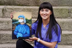 Trainee nurse Chloe Slevin, with her painting 'Corona Lisa' showing Leonarda Da Vinci's Mona Lisa dressed in full PPE.