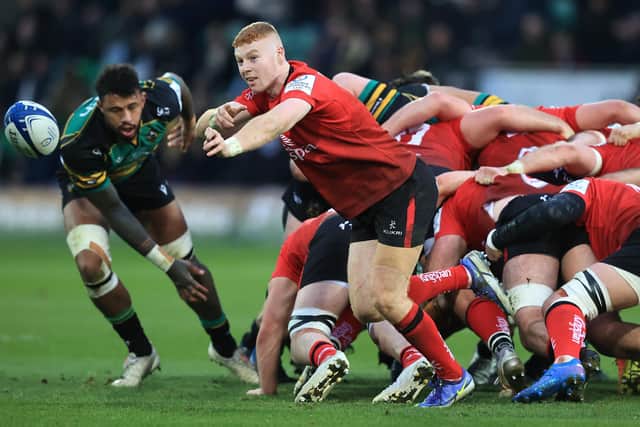 NORTHAMPTON, ENGLAND - JANUARY 16:   Nathan Doak of Ulster passes the ball watched by Courtney Lawes during the Heineken Champions Cup match between Northampton Saints and Ulster Rugby at Franklin's Gardens on January 16, 2022 in Northampton, England. (Photo by David Rogers/Getty Images)