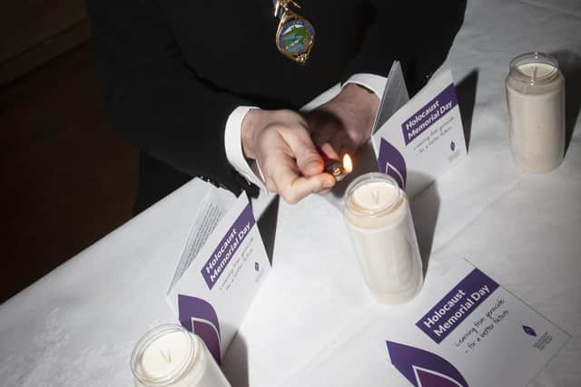 The Mayor of Derry City and Strabane District Council Graham Warke lights a candle at the Waterside Theatre on Thursday morning to mark Holocaust Memorial Day.