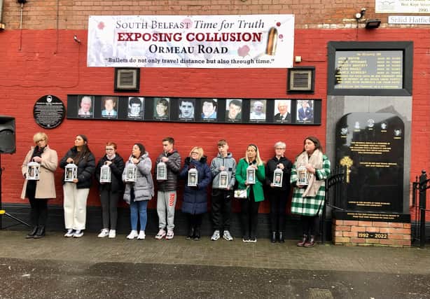 Relatives of the five people murdered in the shooting and relatives of five men injured who have since died gather below a memorial to them holding lit candles during the 30th anniversary commemoration for the 1992 Sean Graham's bookmakers atrocity on Ormeau Road in Belfast.