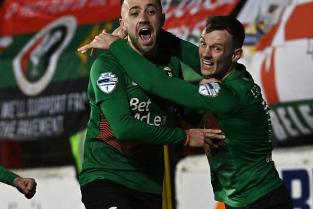 Conor McMenamin (left) celebrates grabbing the game's decisive goal for Glentoran against Linfield in the Premiership top-of-the-table clash. Pic by Pacemaker.