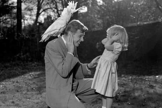 Sir David brings home a cockatoo to show his daugher Susan (3) in 1958. PA archive
