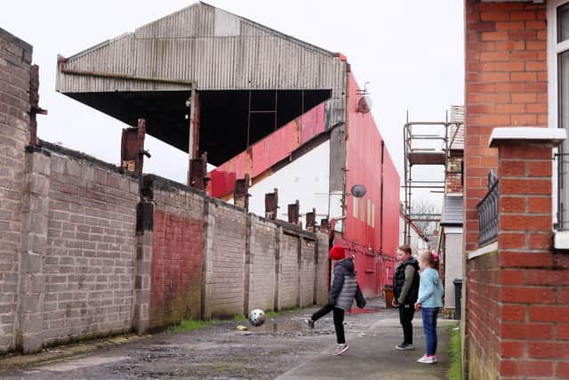Children play at a dilapidated Solitude stadium where Henry McDonald is a lifelong Cliftonville fan. There was better value football matches there some days than from highly paid stars at Goodison Park
