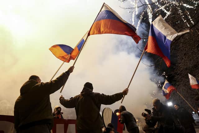People wave Russian national flags to celebrate, in the centre of Donetsk, the territory controlled by pro-Russian militants in eastern Ukraine. AP Photo/Alexei Alexandrov)