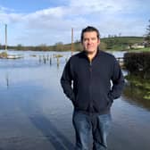 Dessie McKenzie, who lives in Boho and runs the local pub, stands beside one of the flooded roads in the area