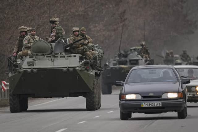 Ukrainian servicemen sit atop armored personnel carriers driving on a road in the Donetsk region, eastern Ukraine, on Thursday after Russian President Vladimir Putin announced a military operation in the country (AP Photo/Vadim Ghirda)