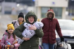 A family arrive at the border crossing in Medyka, Poland after fleeing from the Ukraine.  (AP Photo/Markus Schreiber)