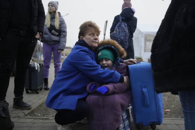 A woman holds a small girl at a border crossing in Medyka, Poland, as refugees flee the Russian invasion of Ukraine. Photo: Markus Schreiber