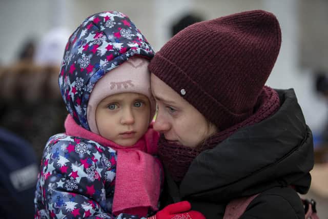 A mother and her child, fleeing Ukraine, wait to board a bus at the border crossing in Medyka, Poland. Picture: AP Photo/Visar Kryeziu