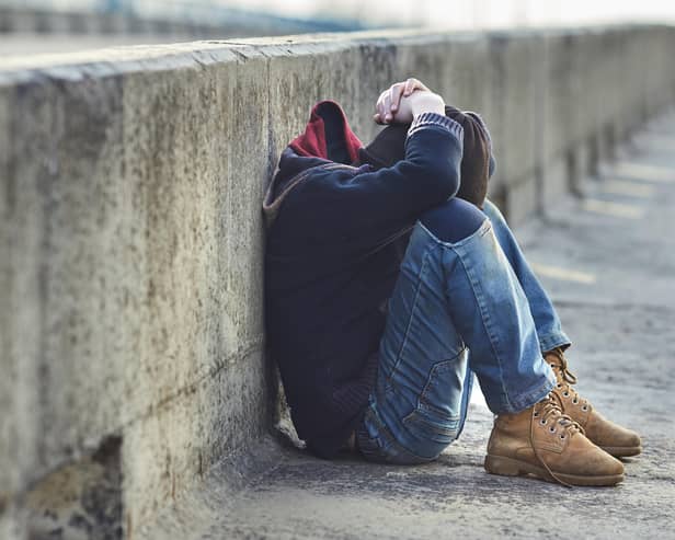 Young homeless boy sleeping on a bridge