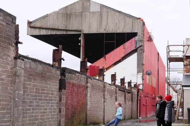 Children play football beside Solitude which is home to Cliftonville FC in north Belfast.