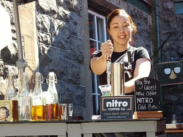 Lucia pouring cold brew coffee from a keg