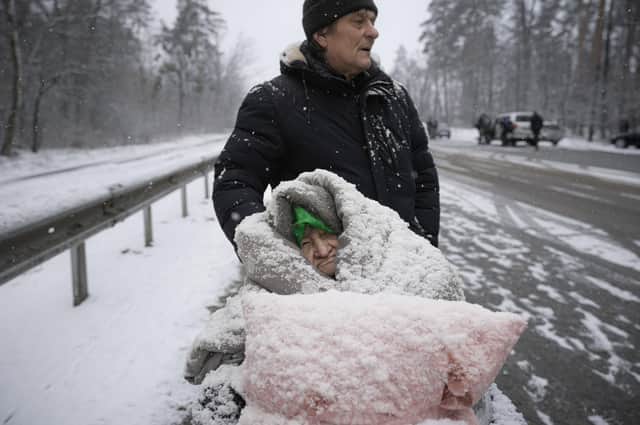 An elderly woman is coated in snow as she sits in a wheelchair after being evacuated from Irpin, on the outskirts of Kyiv, Ukraine, this week. Spring should bring some relief from the bitter conditions, and we can only hope that the war is over long before temperatures cool again in autumn (AP Photo/Vadim Ghirda)