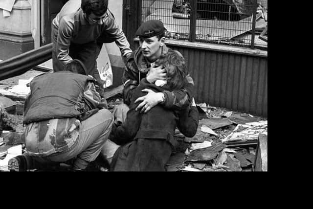A soldier from the Parachute Regiment comforts injured civilian Blanka Sochor close to the News Letter office in March 1972. PA image