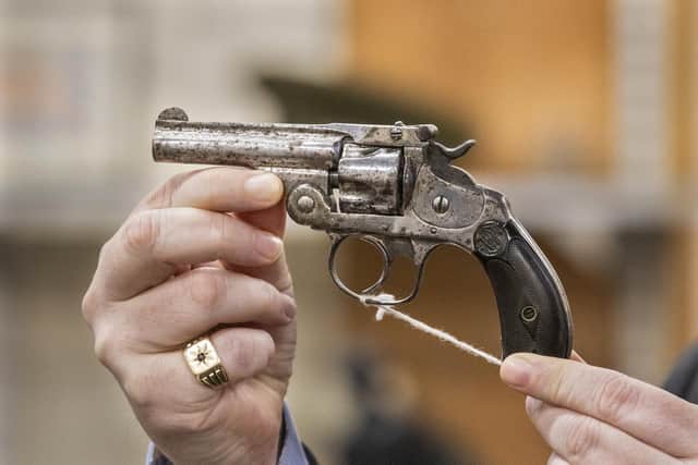Auctioneer Karl Bennett holding a revolver owned by republican leader Michael Collins, was sold for £9,000 as lots linked to the War of Independence/Civil War era went under the hammer at Bloomfield Auctions in east Belfast, in their Michael Collins, Emmet Dalton and Militaria Sale.