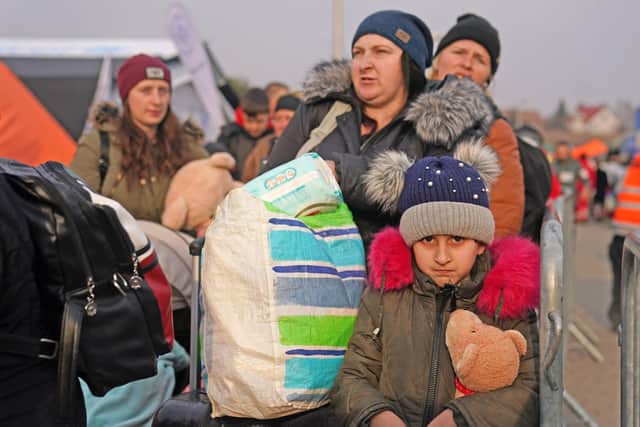 People who have crossed the boarder point from Ukraine into Medyka, Poland, wait to board a bus. Picture date: Wednesday March 16, 2022. PA Photo. See PA story POLITICS Ukraine. Photo credit should read: Victoria Jones/PA Wire