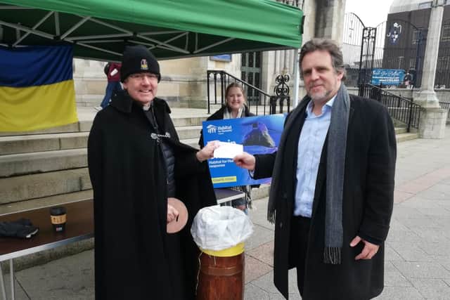 Dean Stephen Forde, of St Anne's Cathedral, Black Santa, receives a £400 donation for Ukraine, sent in an envelope from a News Letter reader, and handed over by the editor Ben Lowry on March 16, 2022