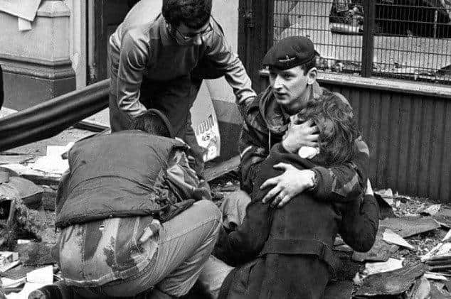 A member of the Parachute Regiment comforts a woman injured when the IRA bombed the News Letter offices in Belfast's Donegall Street in March 1972.