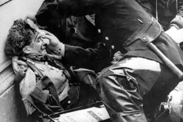A fireman and soldiers treat a woman injured when the IRA detonated a bomb in Donegall Street in March 1972. Photo: Keystone/Getty Images