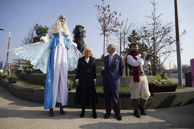 The Prince of Wales and the Duchess of Cornwall with characters from the Lion the Witch and the Wardrobe during a tour of CS Lewis Square, Connswater Greenway, Belfast, to visit the stalls along the Narnia-themed sculpture walk, which showcase East Side Partnership's community activities, on the second day of their two-day visit to Northern Ireland