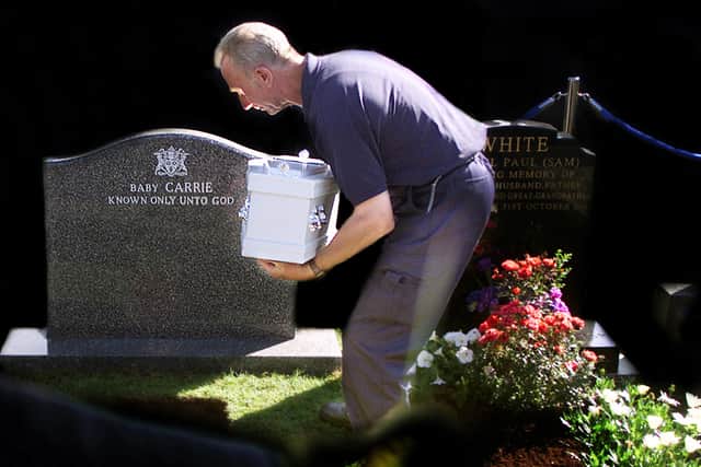 Known only unto God
: A grave digger lays to rest baby 'Carrie' in August 2002. Her unidentified remains were found in Carryduff five months earlier.