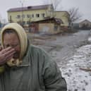 A woman cries outside houses damaged by a Russian airstrike in Gorenka, outside the capital Kyiv, Ukraine.