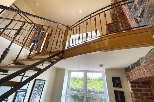 The oak and cast iron bespoke staircase has a gallery landing.