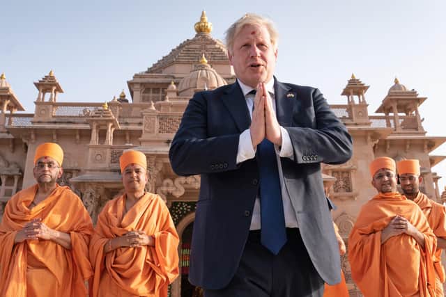 Shoeless Prime Minister Boris Johnson walks with sadhus, Hindu holymen, as he visits the Swaminarayan Akshardham temple in Gandhinagar, Ahmedabad, as part of his two day trip to India. Picture date: Thursday April 21, 2022.
