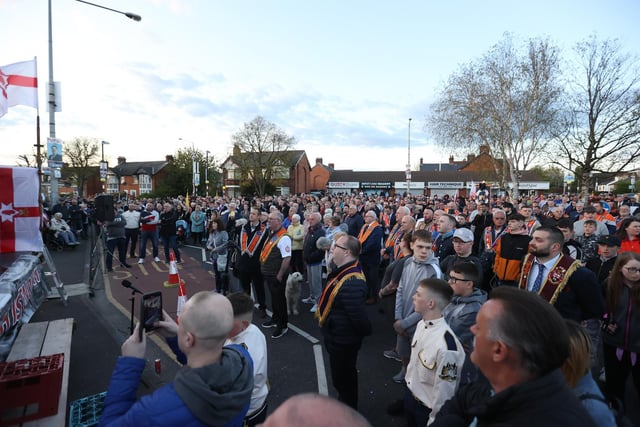 People listen to speakers during an anti Northern Ireland Protocol parade and rally in Broomfield Road