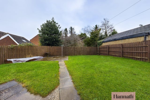 Part of the rear garden which is mainly laid in lawn with patio area and offers privacy with a fence surround.