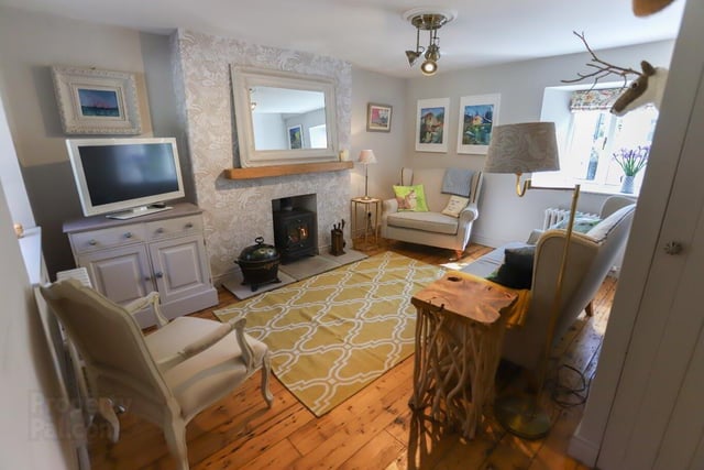The lounge is decorated in chic cottage style and has a wood burning stove.