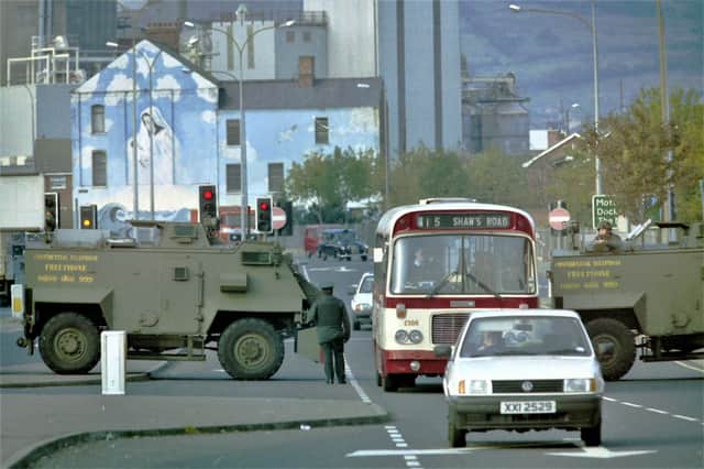25/10/1993: 
RUC and British Army patrol at the bottom of the Falls Road in west Belfast shortly after an IRA bombing; in the background is a mural dedicated to Christ and Mary