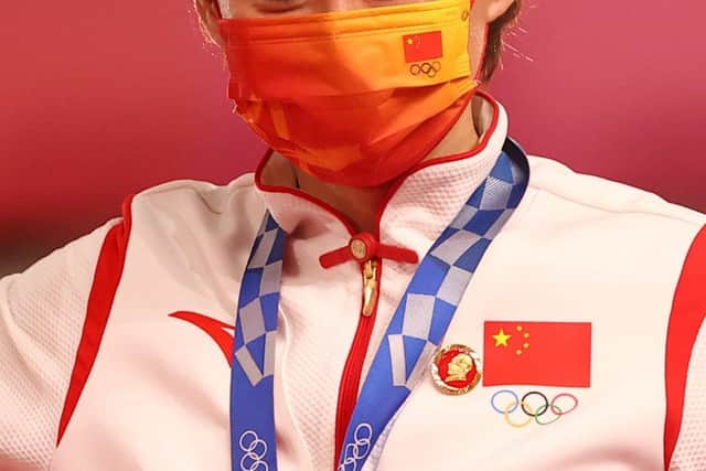 Gold medalist Zhong Tianshi wears a badge of Mao Zedong during her medal ceremony at the Tokyo Olympics 2021