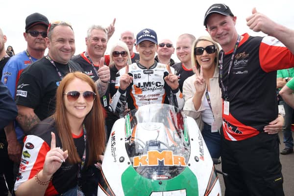 Richard Cooper celebrates his opening Supertwin race victory at the North West 200 on Saturday with the J McC Roofing team plus Ryan Farquhar and wife Karen (right).