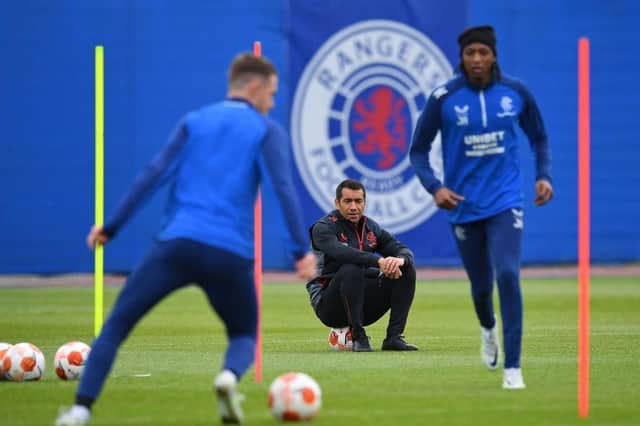 Rangers' Dutch manager Giovanni van Bronckhorst (C) watches Rangers' Welsh midfielder Aaron Ramsey (L) and Rangers' Nigerian midfielder Joseph Ayodele-Aribo at a team training session at the Rangers Training Centre in Glasgow ahead of their Europa League final football match against Eintracht Frankfurt on May 18th. Photo by ANDY BUCHANAN/AFP via Getty Images