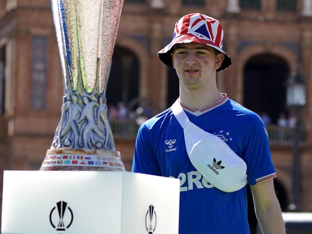 Rangers fan Callum Wilson gets a photo with the Europa League trophy in the Plaza de Espana before the UEFA Europa League Final at the Estadio Ramon Sanchez-Pizjuan, Seville.