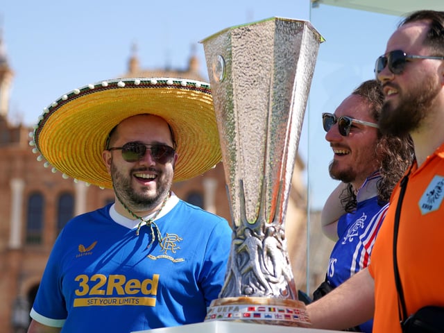 Rangers fans get their photo taken with the the Europa League trophy in the Plaza de Espana before the UEFA Europa League Final at the Estadio Ramon Sanchez-Pizjuan, Seville.