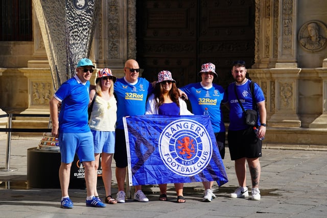 Rangers fans pose for a picture in front of a replica UEFA Europa League trophy on display in the old town of Seville, ahead of the UEFA Europa League Final at the Estadio Ramon Sanchez-Pizjuan.