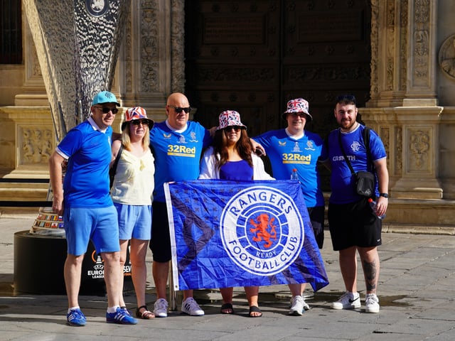 Rangers fans pose for a picture in front of a replica UEFA Europa League trophy on display in the old town of Seville, ahead of the UEFA Europa League Final at the Estadio Ramon Sanchez-Pizjuan.