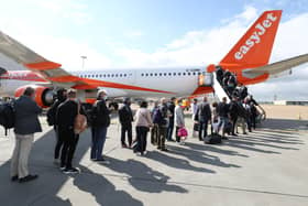 File photo dated 17/05/21 of passengers prepare to board an easyJet flight to Faro, Portugal, at Gatwick Airport in West Sussex, as the airline hopes to be back to carrying nearly as many customers at the end of this financial year as it did before the pandemic.