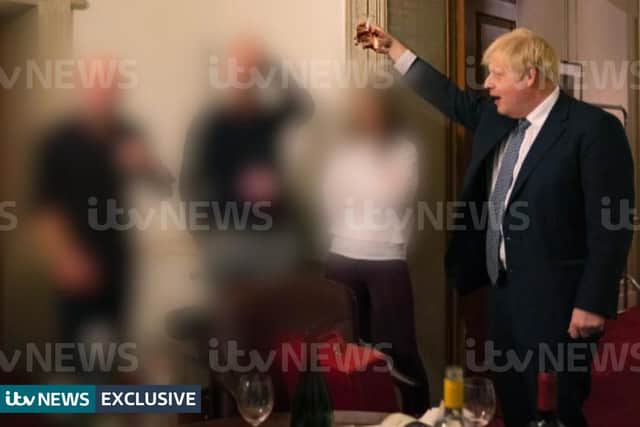 A photograph obtained by ITV News of the Prime Minister raising a glass at a leaving party on 13th November 2020, with bottles of alcohol and party food on the table in front of him