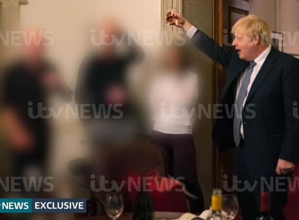 A photograph obtained by ITV News of the Prime Minister raising a glass at a leaving party on 13th November 2020, with bottles of alcohol and party food on the table in front of him