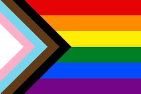 AN LGBTQQIABLM+ flag; a gay pride rainbow incorporating the pink and baby-blue of the transgender movement, plus black & brown for Black Lives Matter