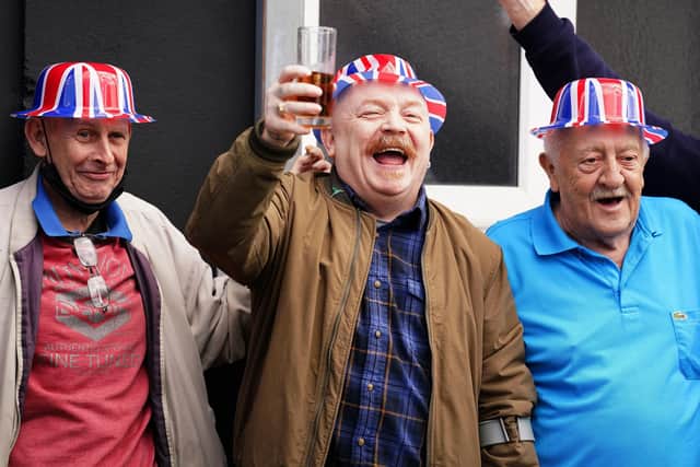 Men enjoy the atmosphere outside a pub at a street party on Donegal Pass in Belfast city centre