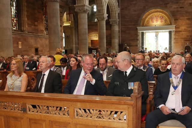 Conor Burns MP (with hand raised) speaking to Chief Constable Simon Byrne, alongside other dignitaries, including Sinn Fein Lord Mayor of Belfast Tina Black (far left)